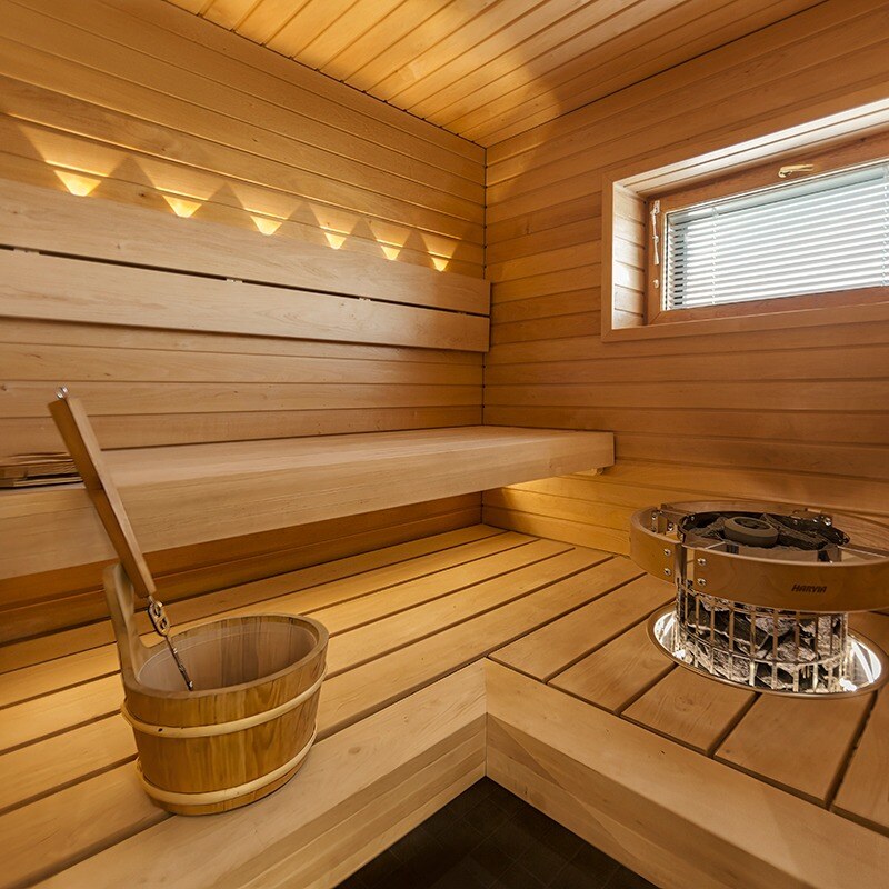 Remontoitu sauna jossa LED-valaistus ja lauteisiin upotettu pilarikiuas