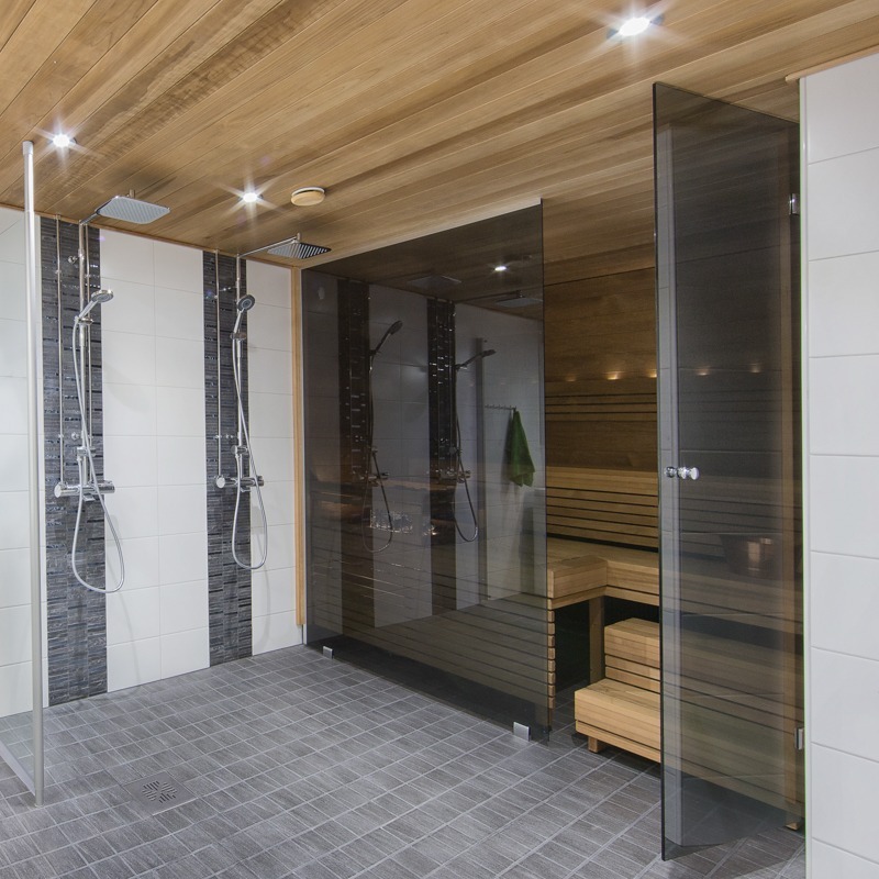 Moderni sauna tummennetulla lasiseinällä