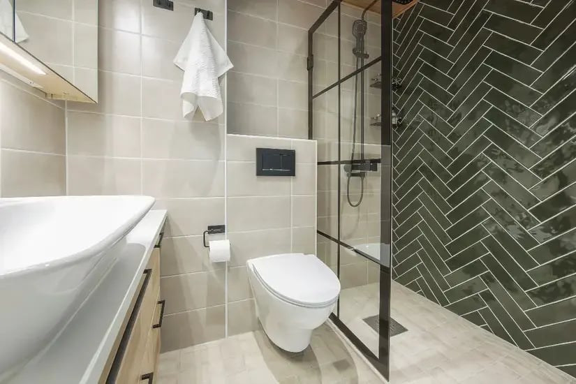 Uusi kylpyhuone jossa seinä-WC, lasinen suihkuseinä sekä kalanruoto tehosteseinä